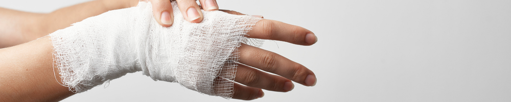 Close-up of an injured hand wrapped in white gauze bandages, symbolising personal injury and medical treatment